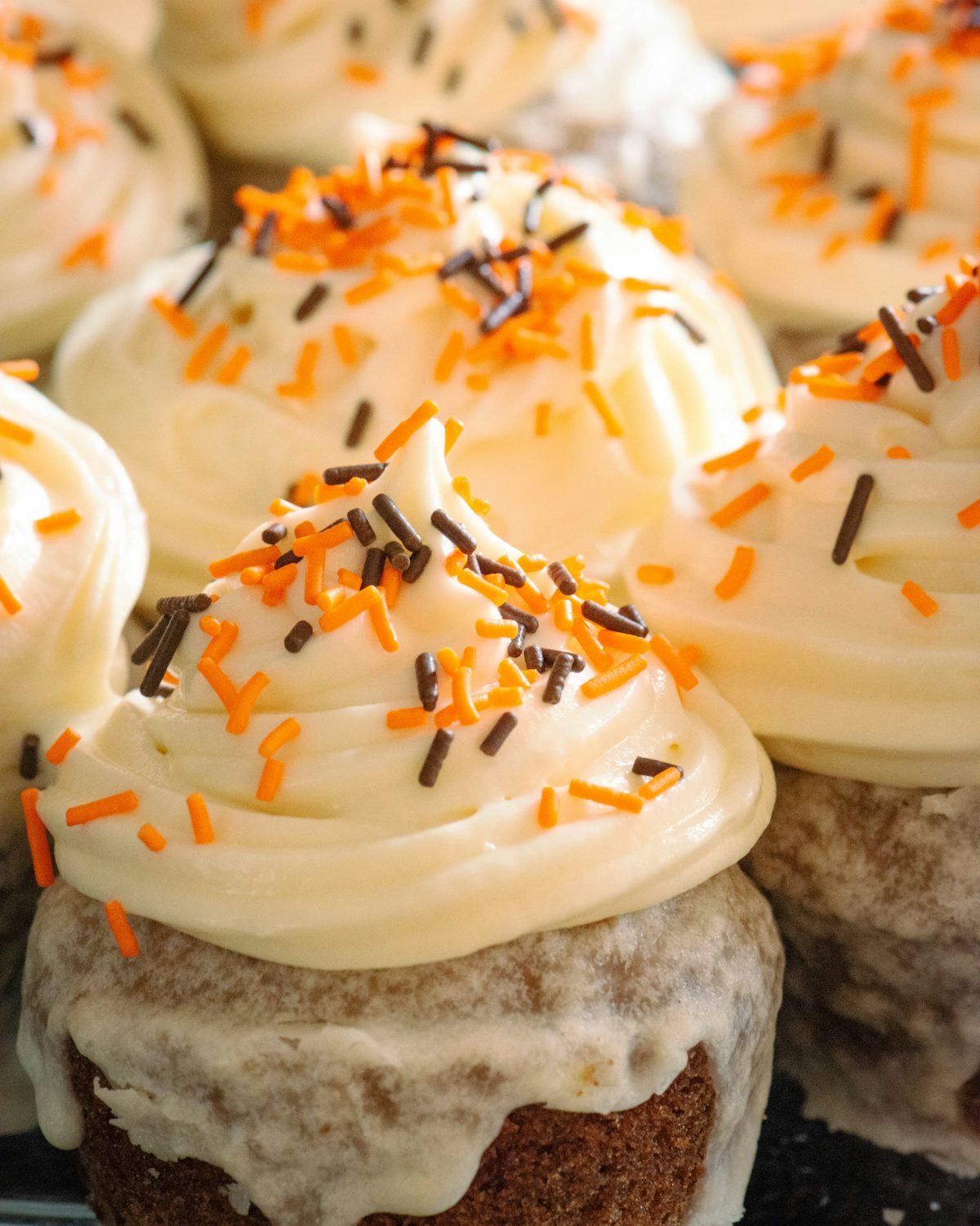 Orange pumpkin-spice cupcakes with white frosting for fall